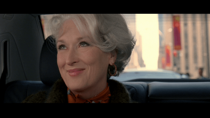 Close-up of Miranda momentarily looking happy in the backseat of her car