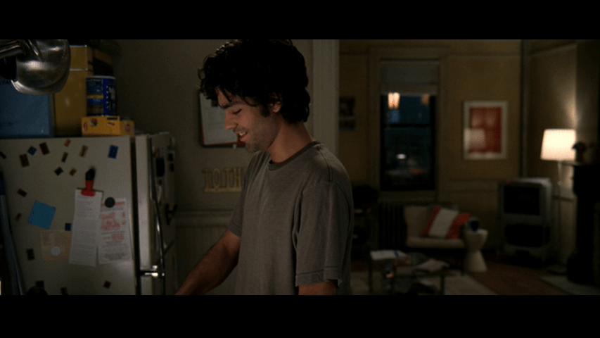 Medium shot of Nate laughing as he looks down at his pan