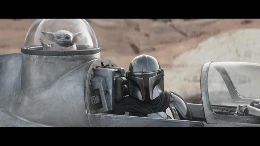 Medium shot of Mando from the other side, this time with Grogu visible behind him