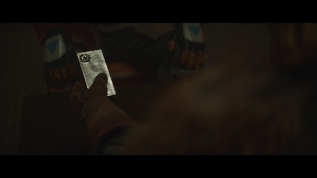 Close up of the Armorer picking up the Beskar
