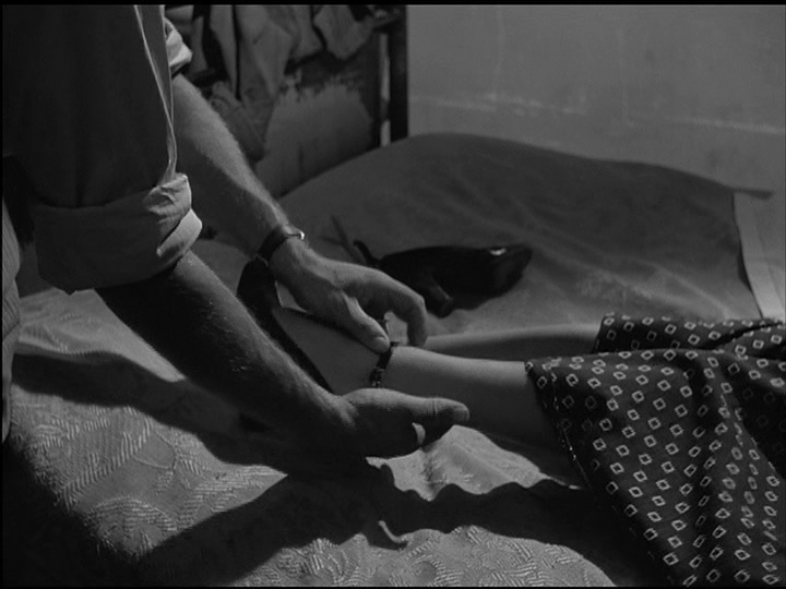 Close-up of Gastone Renzelli's Spartaco Cecconi removing his wife Maddalena's (Anna Magnani) second high heel; the first lies on the bed next to her legs