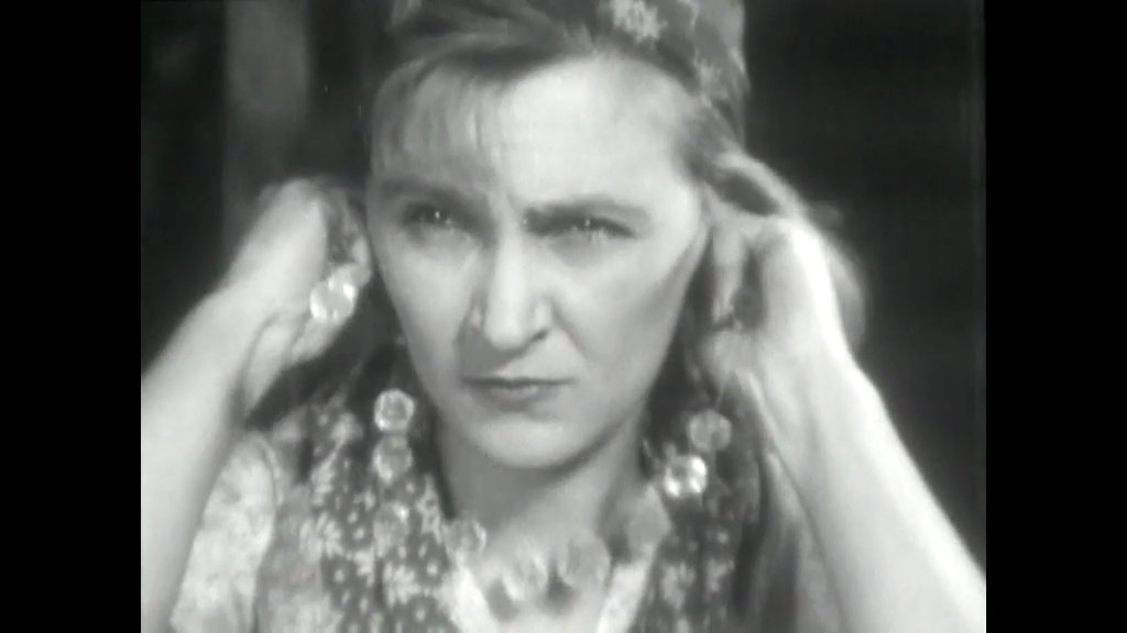 Close-up of Maria snapping the string of the pearl necklace, causing the pearls to fall to the floor in slow motion