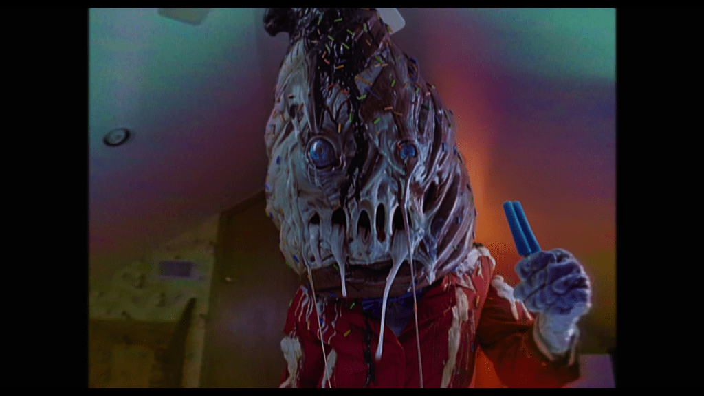 Reverse shot showing what the child was looking at: a giant ice cream cone man whose face is melting