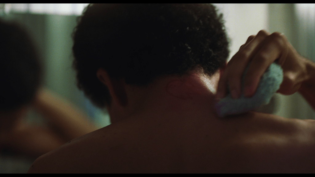 Close-up of Owen scrubbing away at the tattoo Maddy gave him with a washcloth