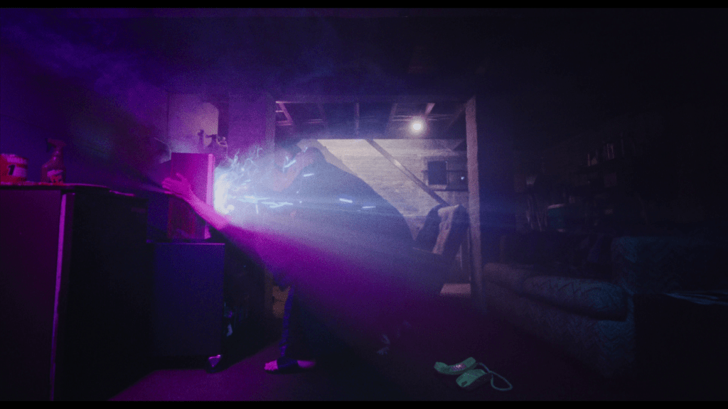 Long shot of Owen's father rushing into a room to pull his son out of the television