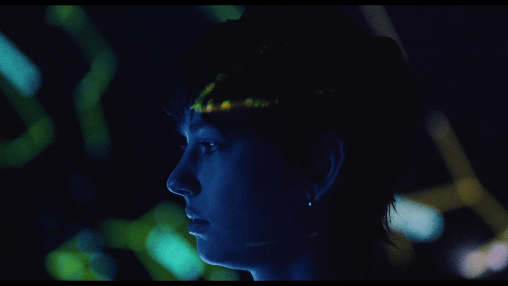 Close-up of Maddie in profile lit by the light of a planetarium