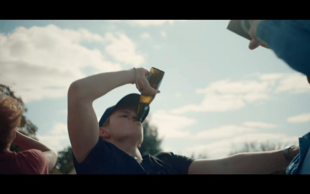 Low angle close-up of a teen chugging a beer