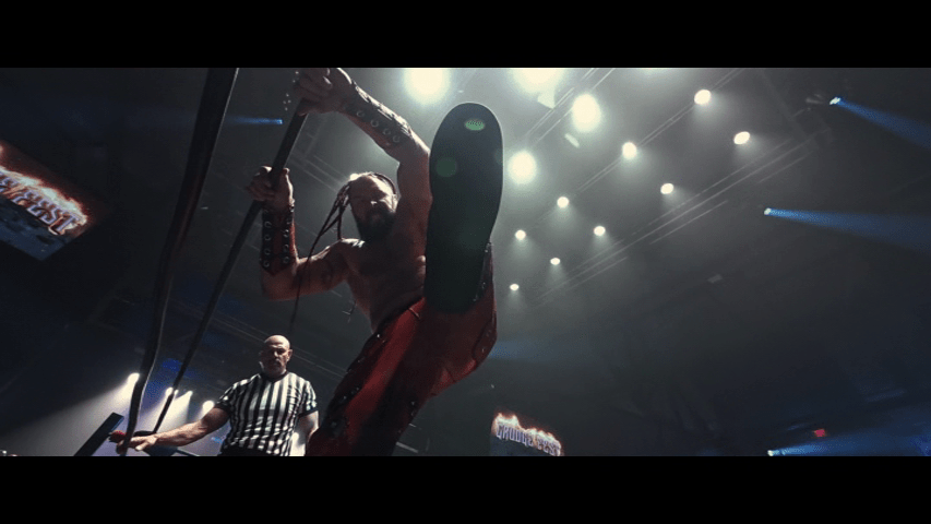 Low-angle shot of a pro wrestler's boot about the stomp the person whose perspective it represents