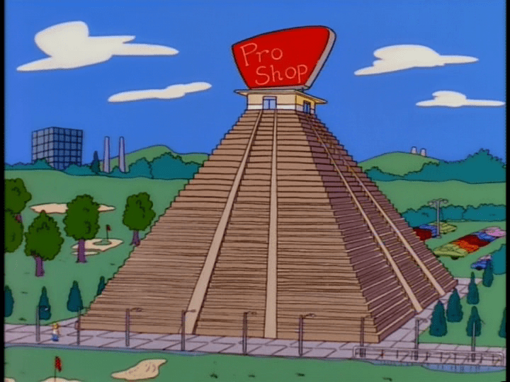 Extreme long shot of Homer in the left corner of the frame looking up at a comically large pro shop shaped like a Mesoamerican pyramid
