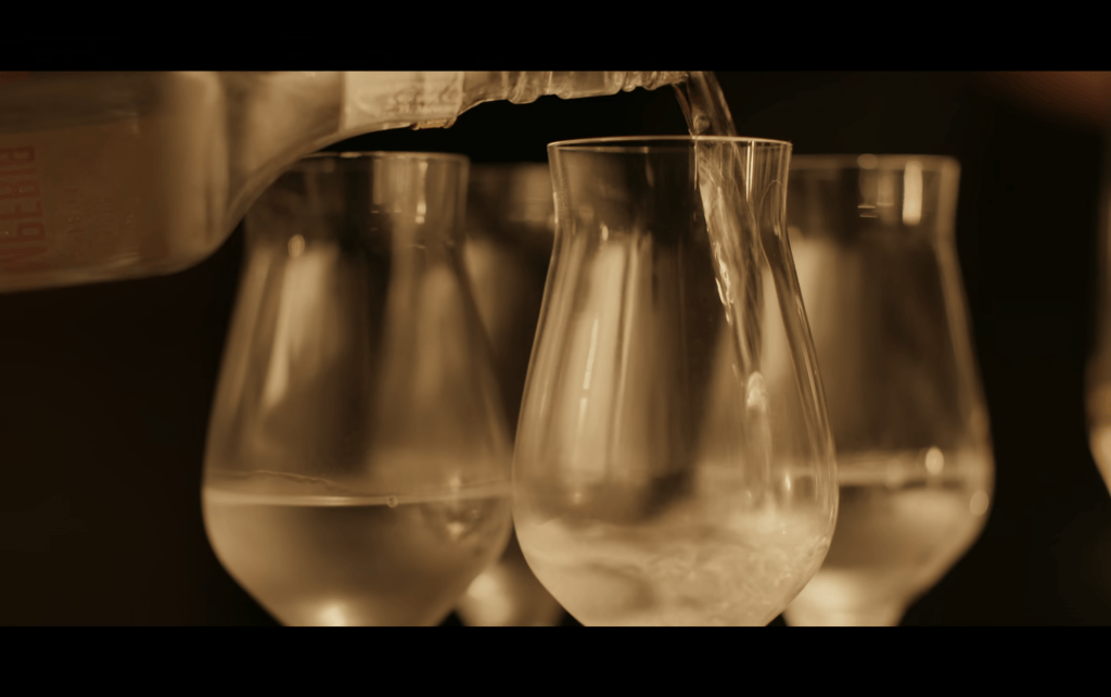 Close-up of vodka being poured into a flight of four glasses
