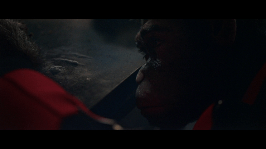 Close-up of Williams, who is depicted as a chimpanzee, lifting his head up from a table covered in cocaine