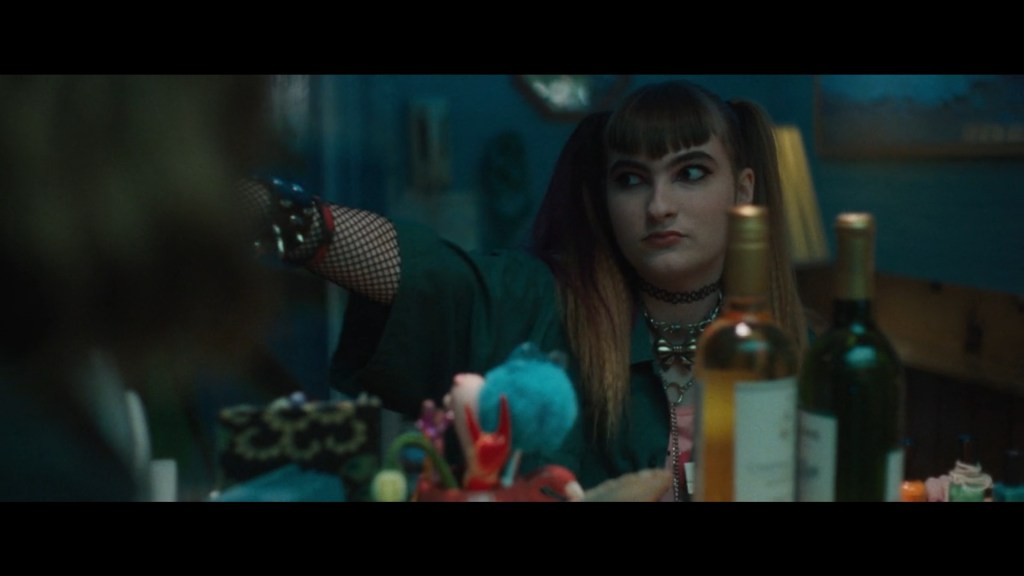 Close-up of Ivy Wolk's hotel manager Diana pointing offscreen right from behind the cash register