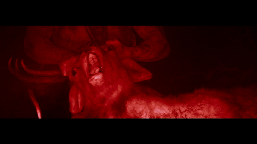 Nighttime close-up of Samson's hands twisting a deer's head shot with a red filter