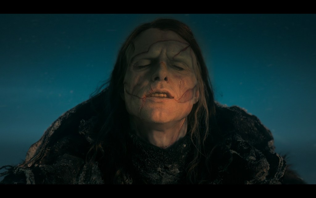 Close-up of The Creature (Jacob Elordi) following his creator's advice and finally beginning to "live" by enjoying the feel of an arctic sunrise on his face
