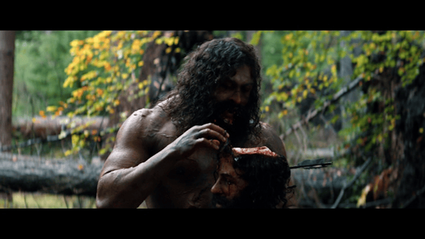 Medium close-up of Samson eating brains out of a decapitated skull